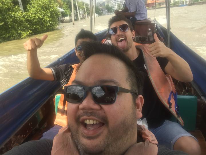 People making funny faces in a boat wearing life jackets.