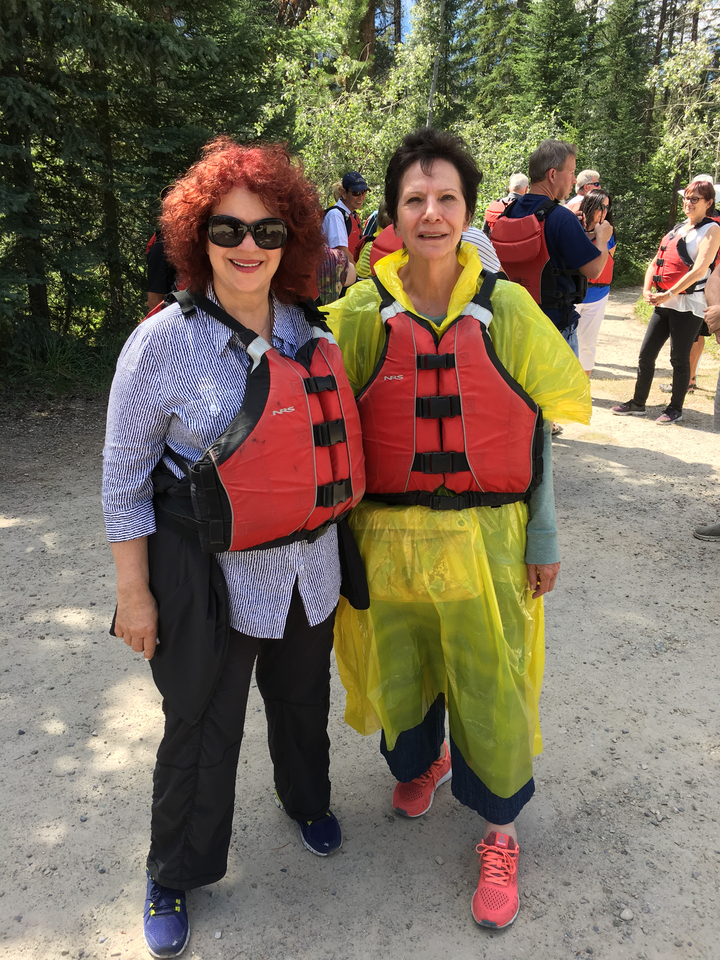 Deux personnes portant des gilets de sauvetage posant en plein air.