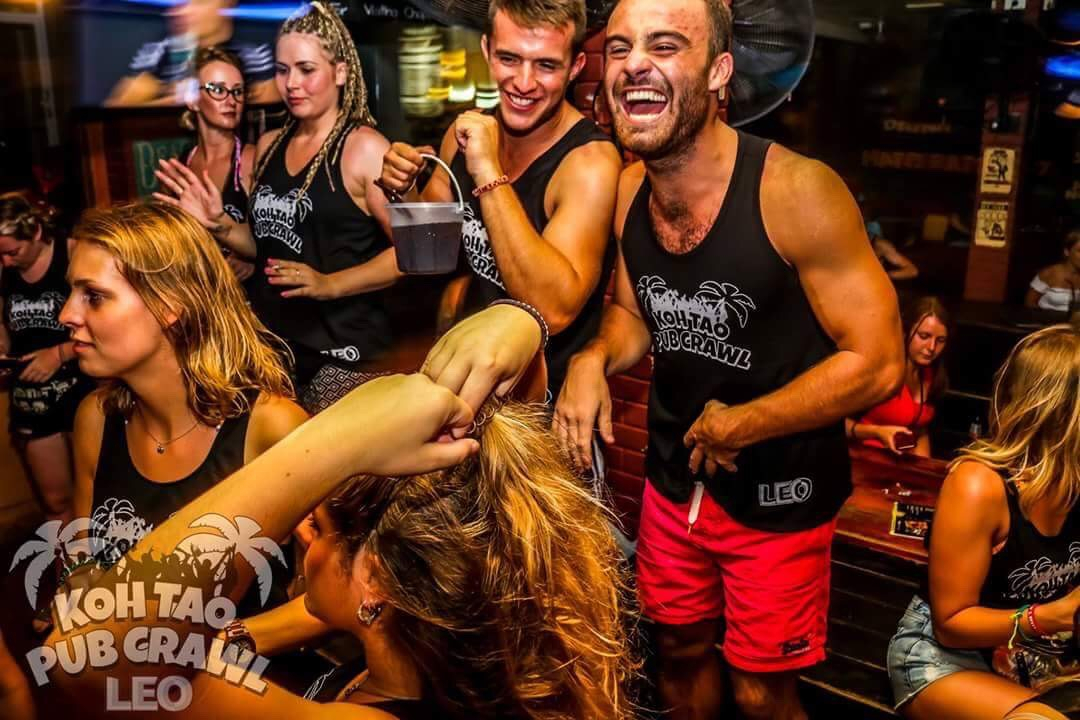 Group of people partying inside a crowded venue.