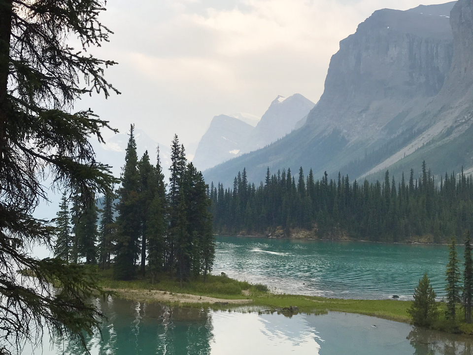 A picturesque lake with mountains and pine trees.