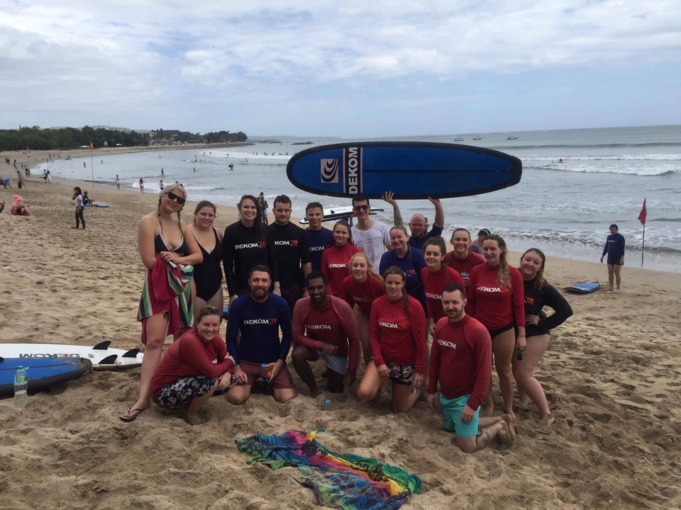 Group of people with surfboards on a beach.