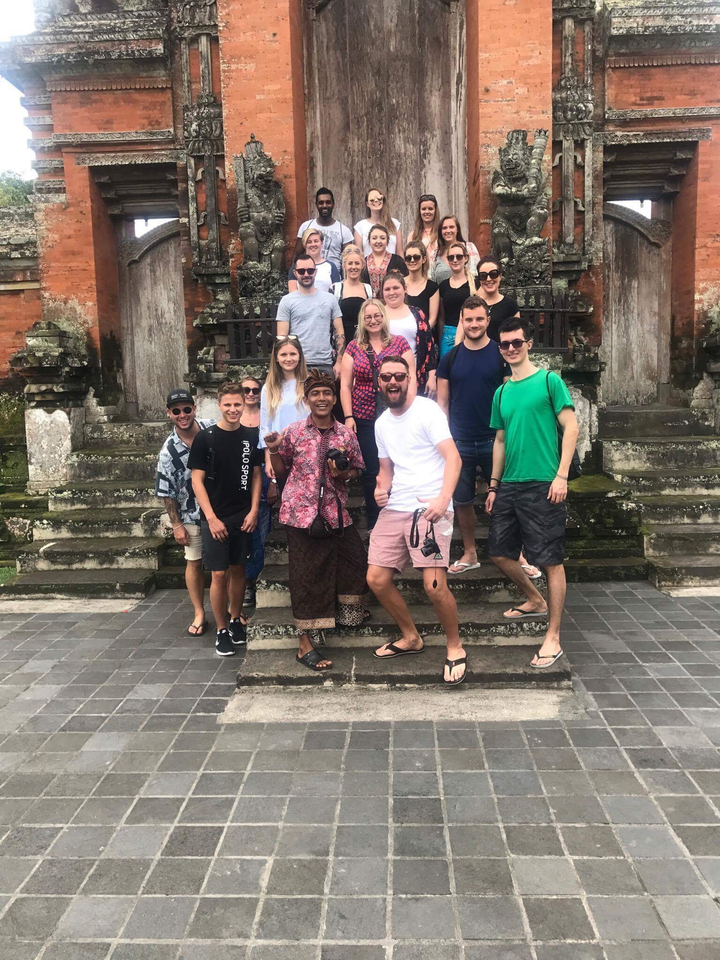 Group of people posing at a temple entrance.