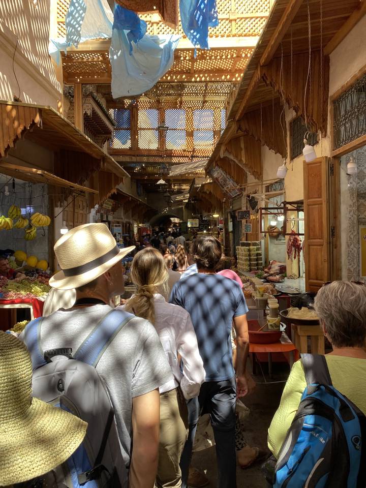 Crowded market alley with shoppers.