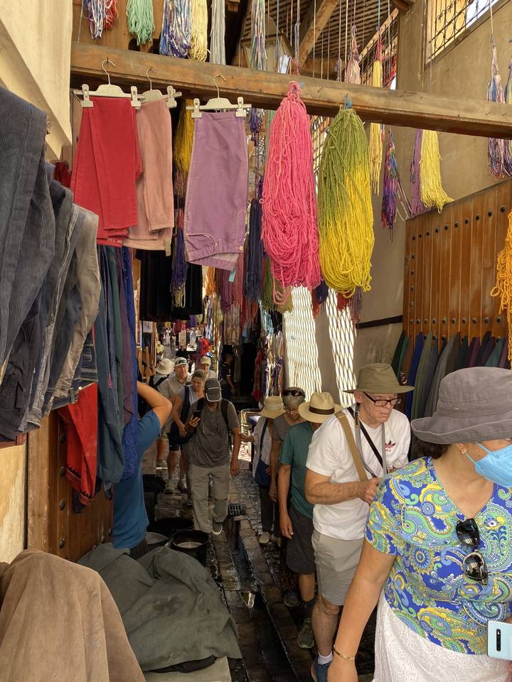 Bright textiles hanging in a bustling market.