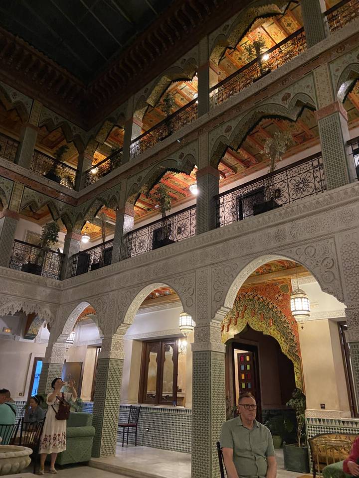 Ornate interior of a Moroccan building with sitting area.