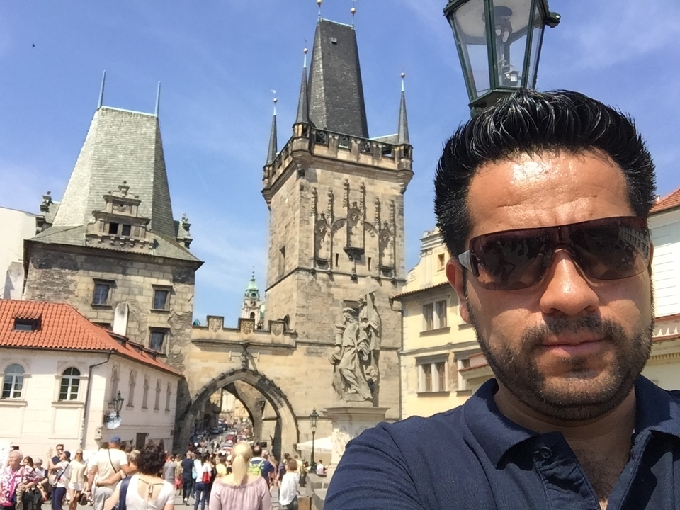Selfie in front of historic arched buildings and towers.