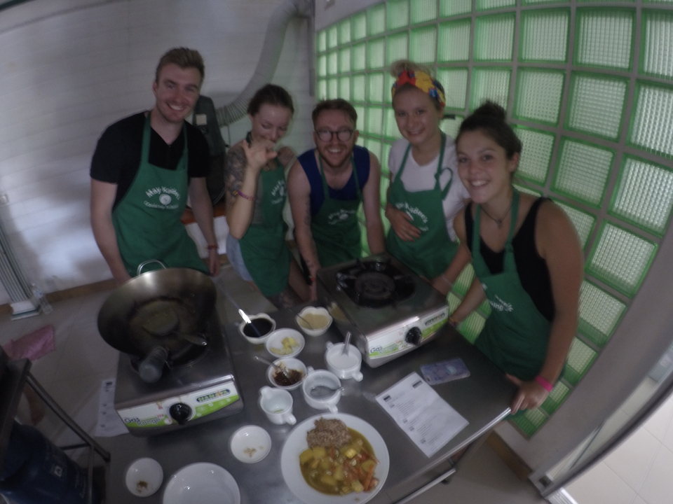 People in a cooking class room, partially blurred.