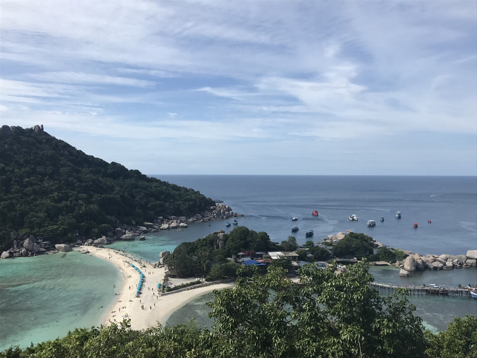 Picturesque bay with boats and clear blue water seen from above.