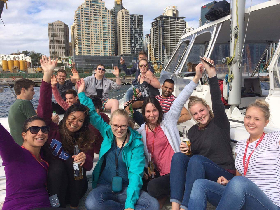 Group of people on a boat with high-rise buildings in the background.