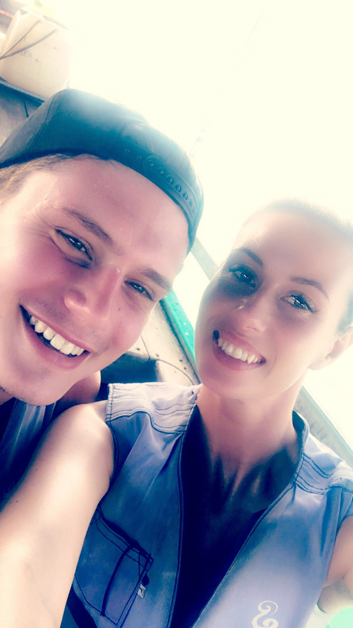 A close-up of two people smiling at the camera.