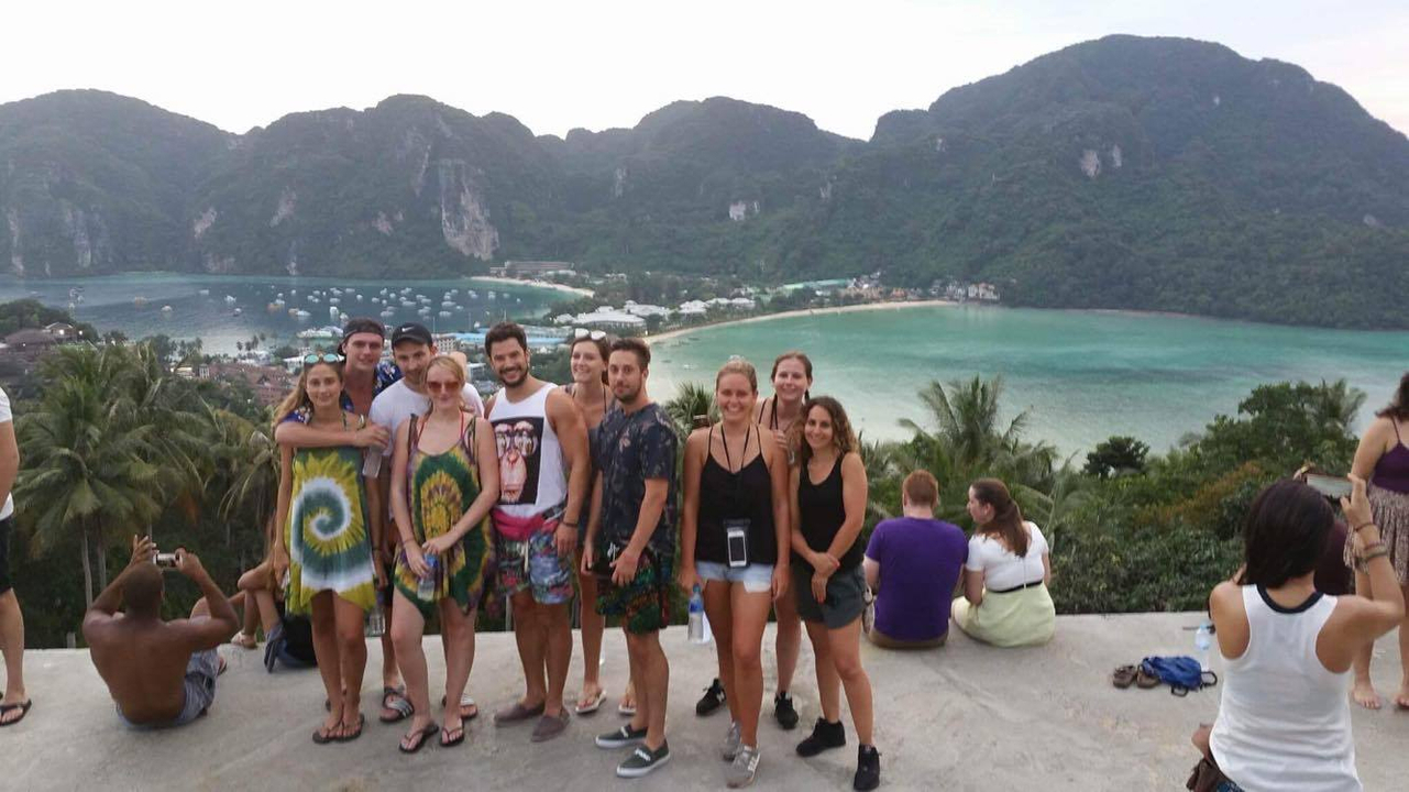 Group photo with a scenic beach view in the background.