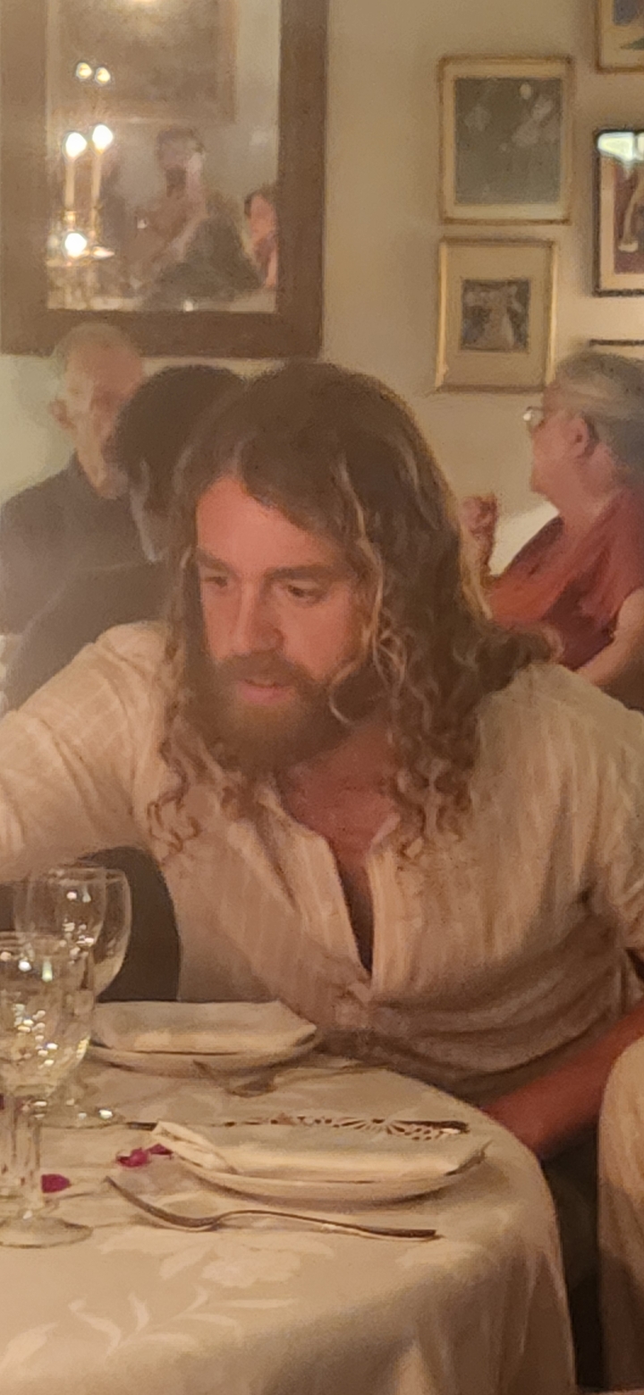 Cadre intérieur avec un homme concentré sur quelque chose hors champ.