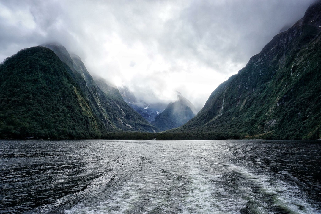 Stunning fjord landscape with misty mountains and a body of water.