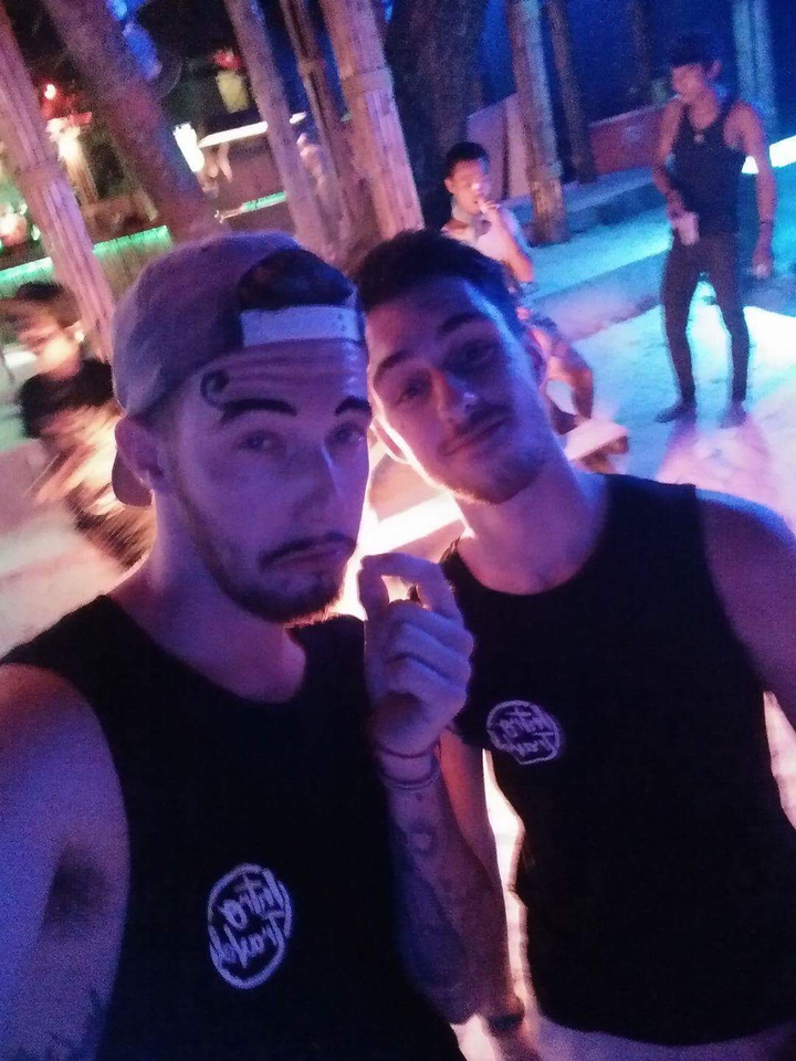 Two people posing in a party with dim lighting, photo is out of focus.