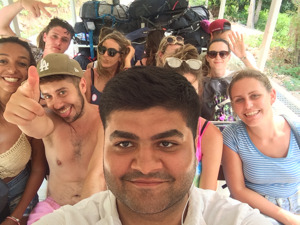 A group of people posing for a selfie on a vehicle.