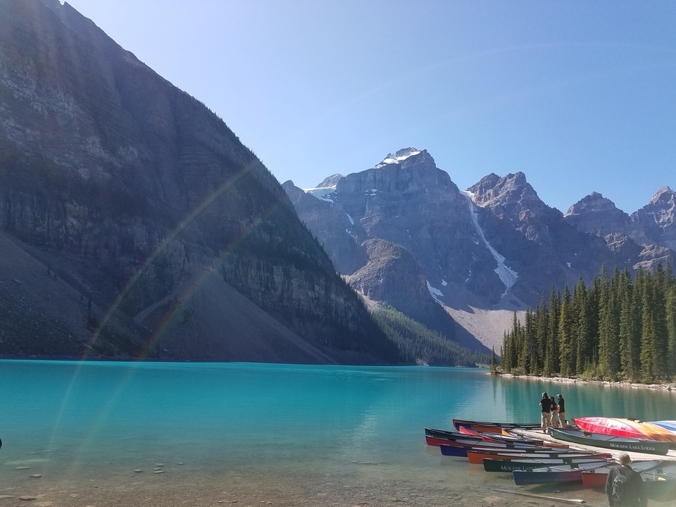 Lac de montagne à l'eau turquoise avec des personnes sur le quai.