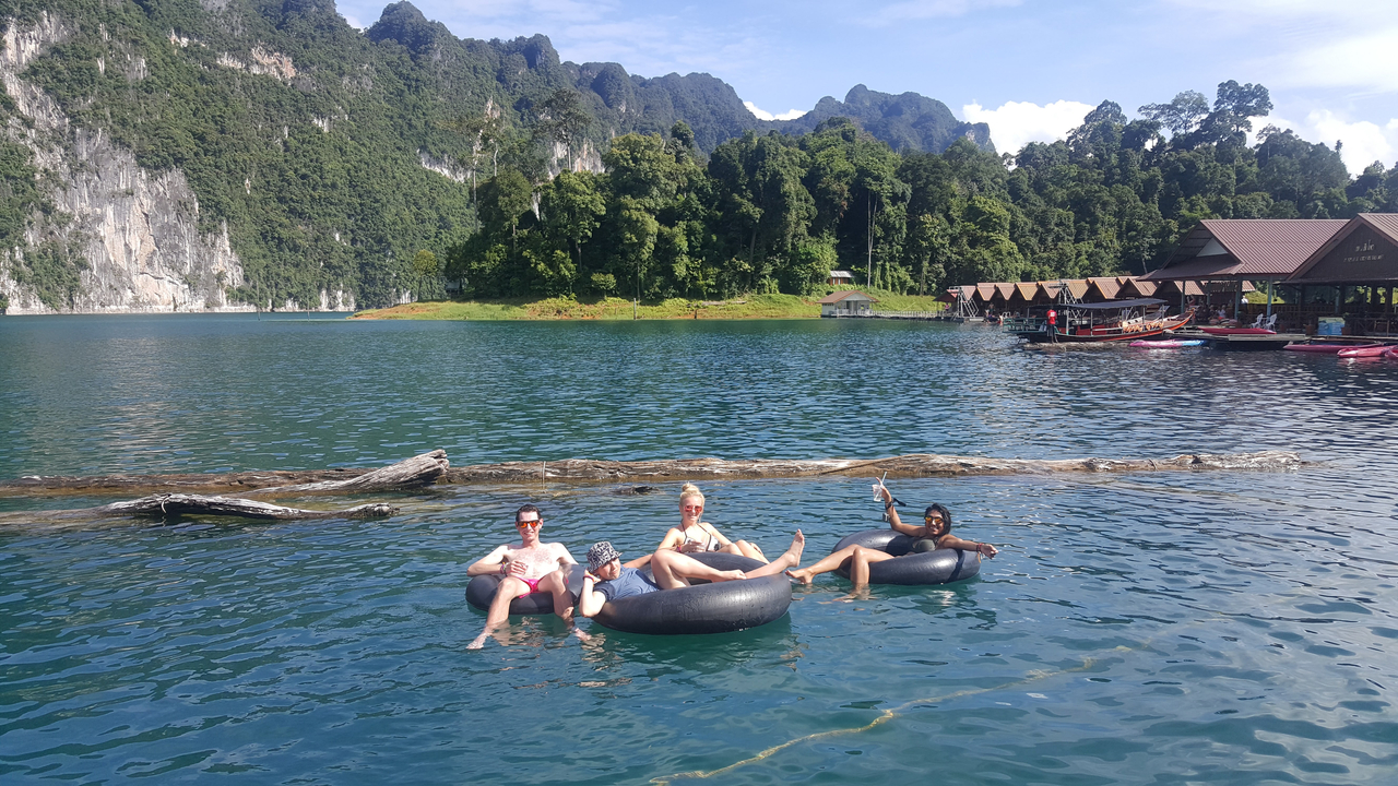 People relaxing on tubes in a beautiful lake with mountains in the background