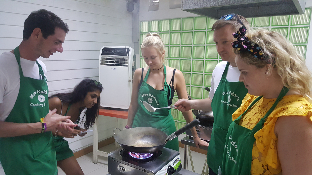 Group of people cooking in a class setting