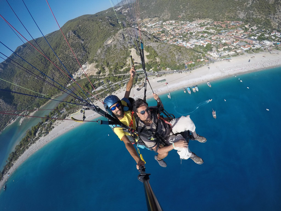 Parapente en tandem au-dessus d'une zone côtière avec une vue dégagée sur le rivage