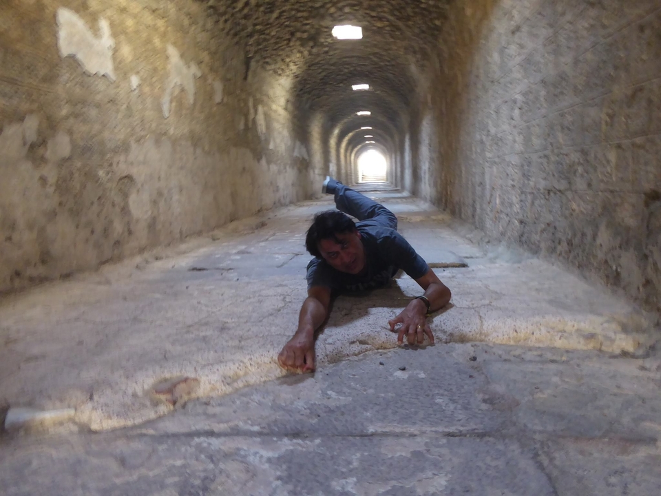 Personne allongée dans un couloir historique en pierre