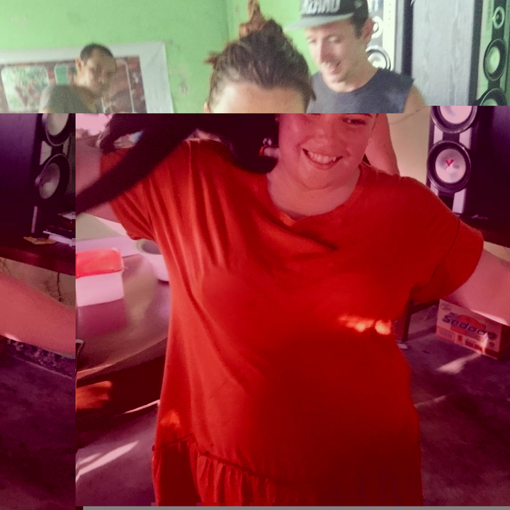 Smiling person with red shirt in a room.