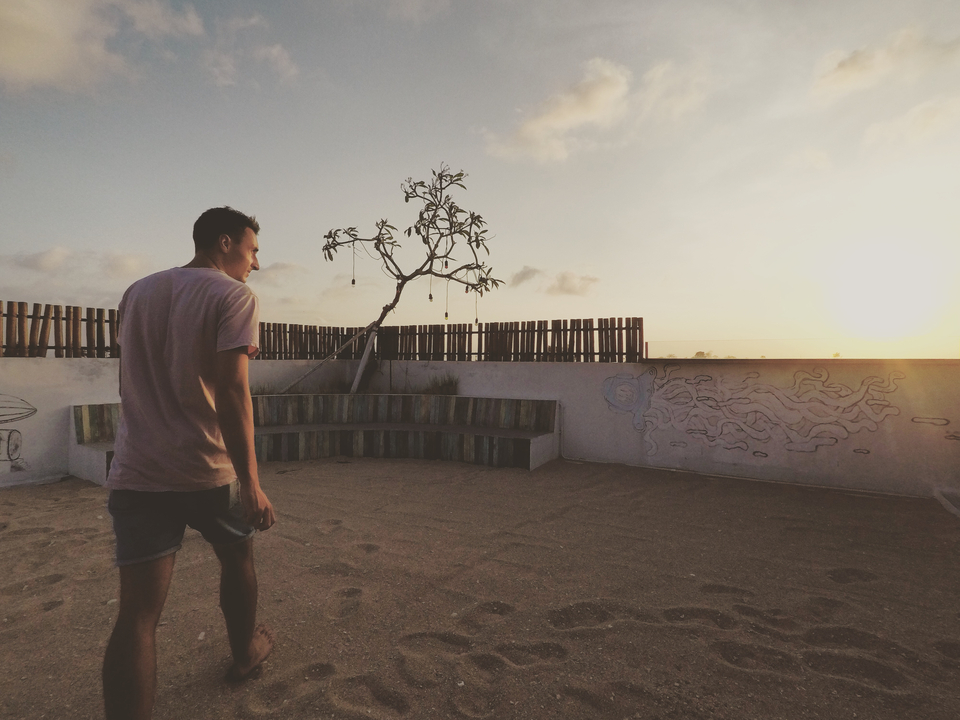 Person walking in a courtyard during sunset.