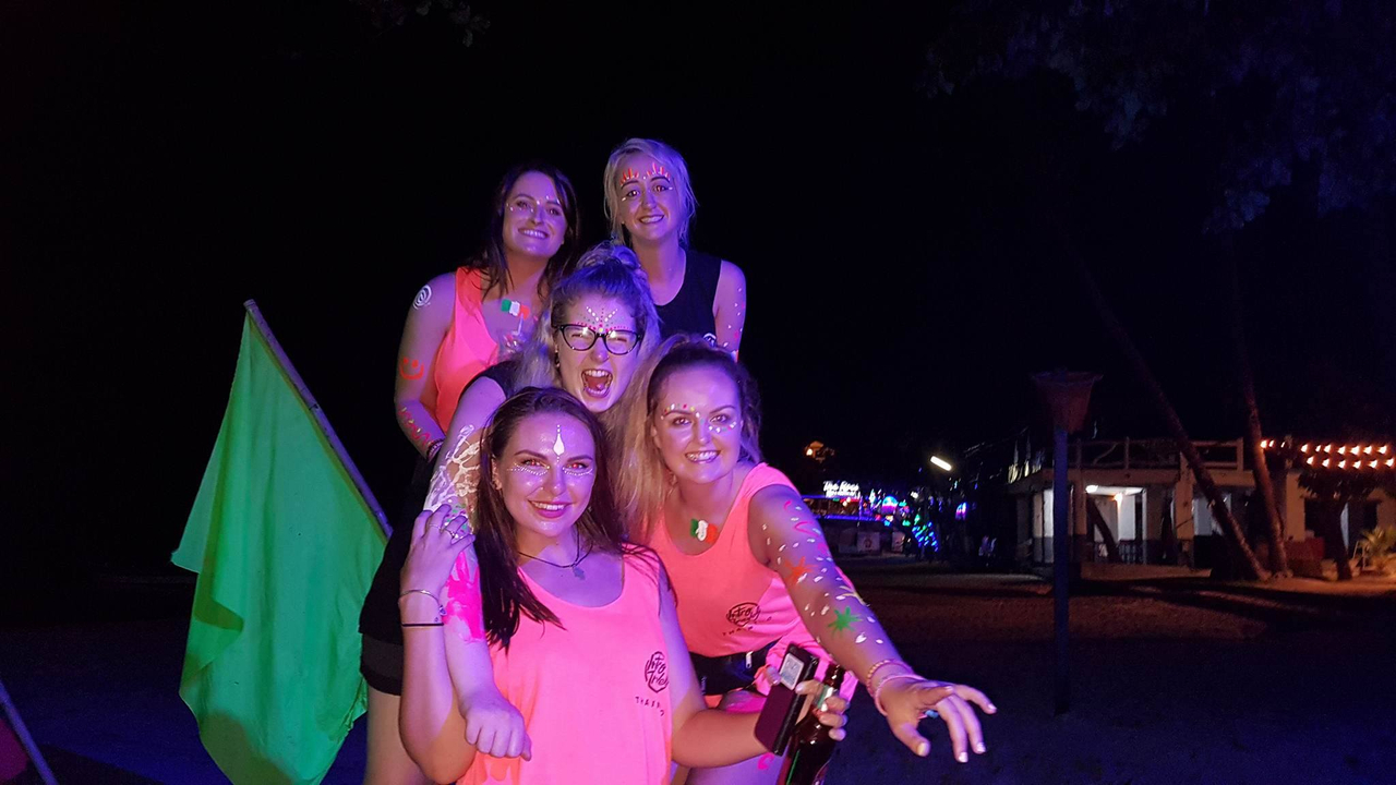 Friends enjoying a night party with neon colors.