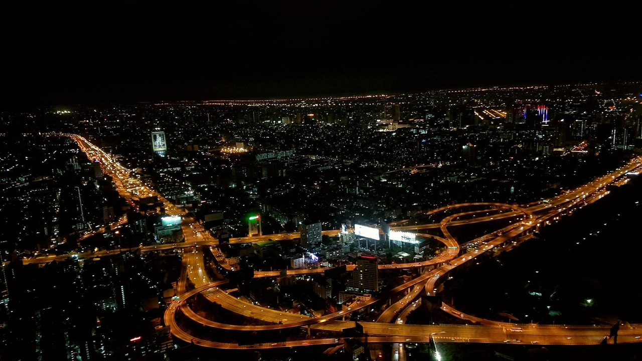 Aerial view of a city at night with illuminated roads.