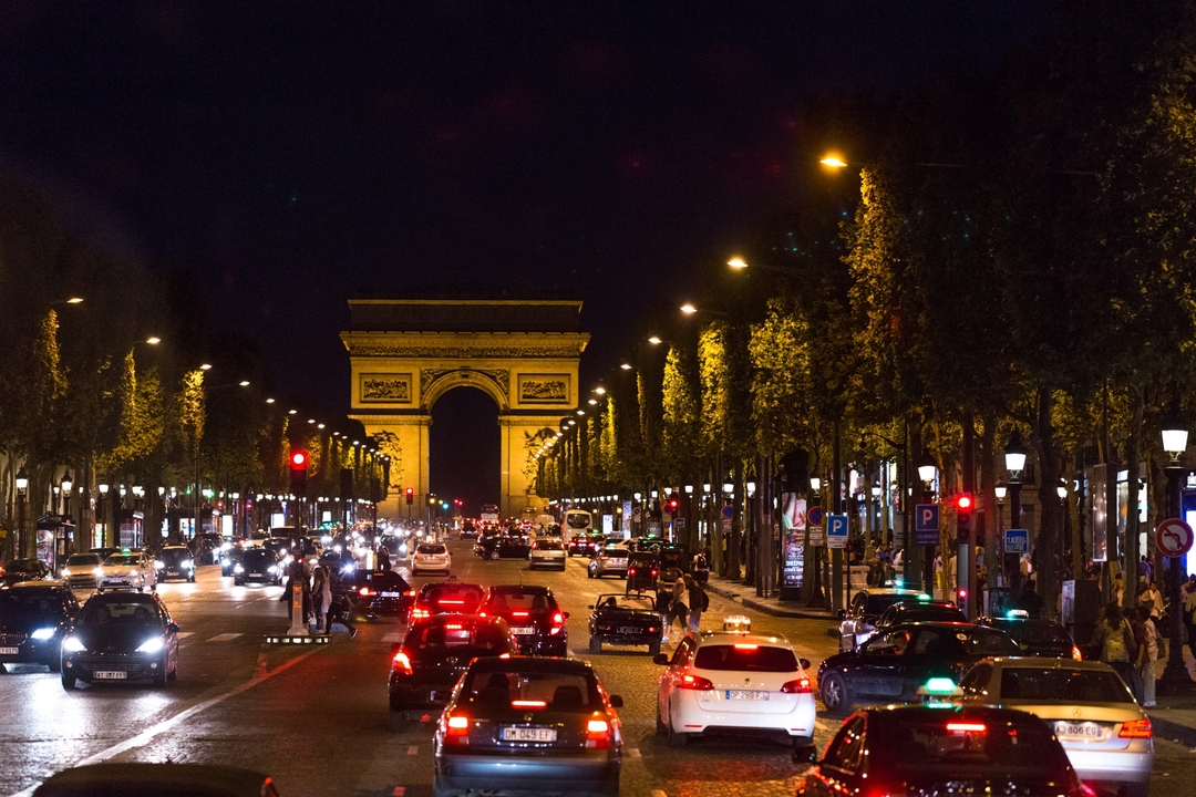 View of the Arc de Triomphe with traffic at night.