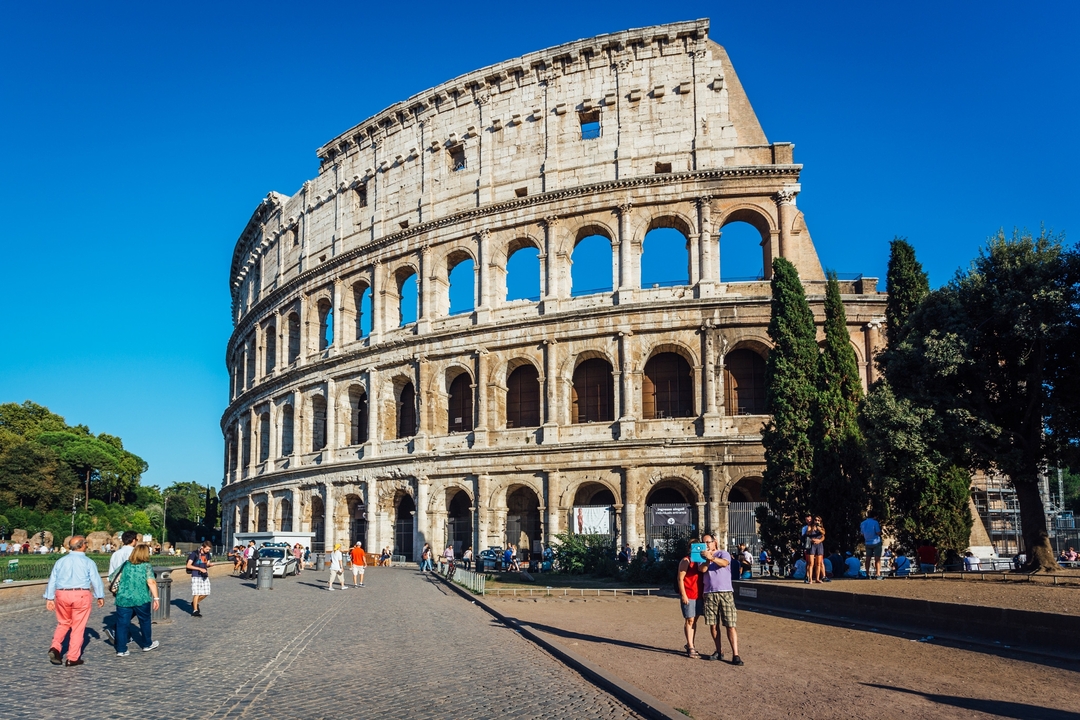 The Colosseum in Rome with people walking by.