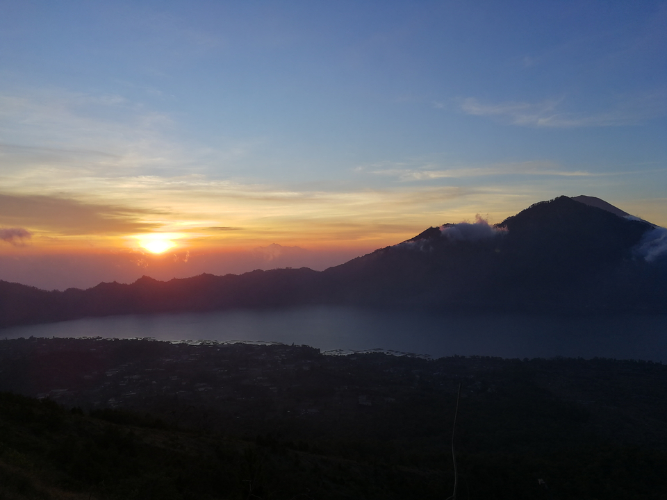 Sunrise view over mountains and a lake.