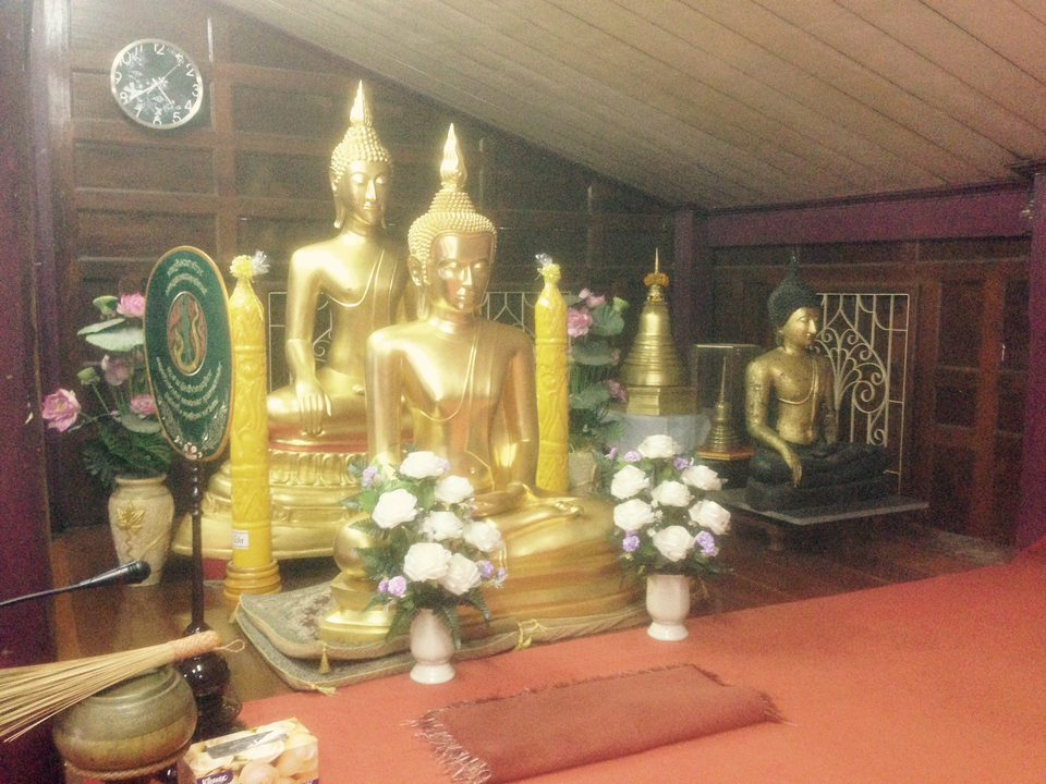 Golden Buddha statues inside a temple with decorated surroundings.