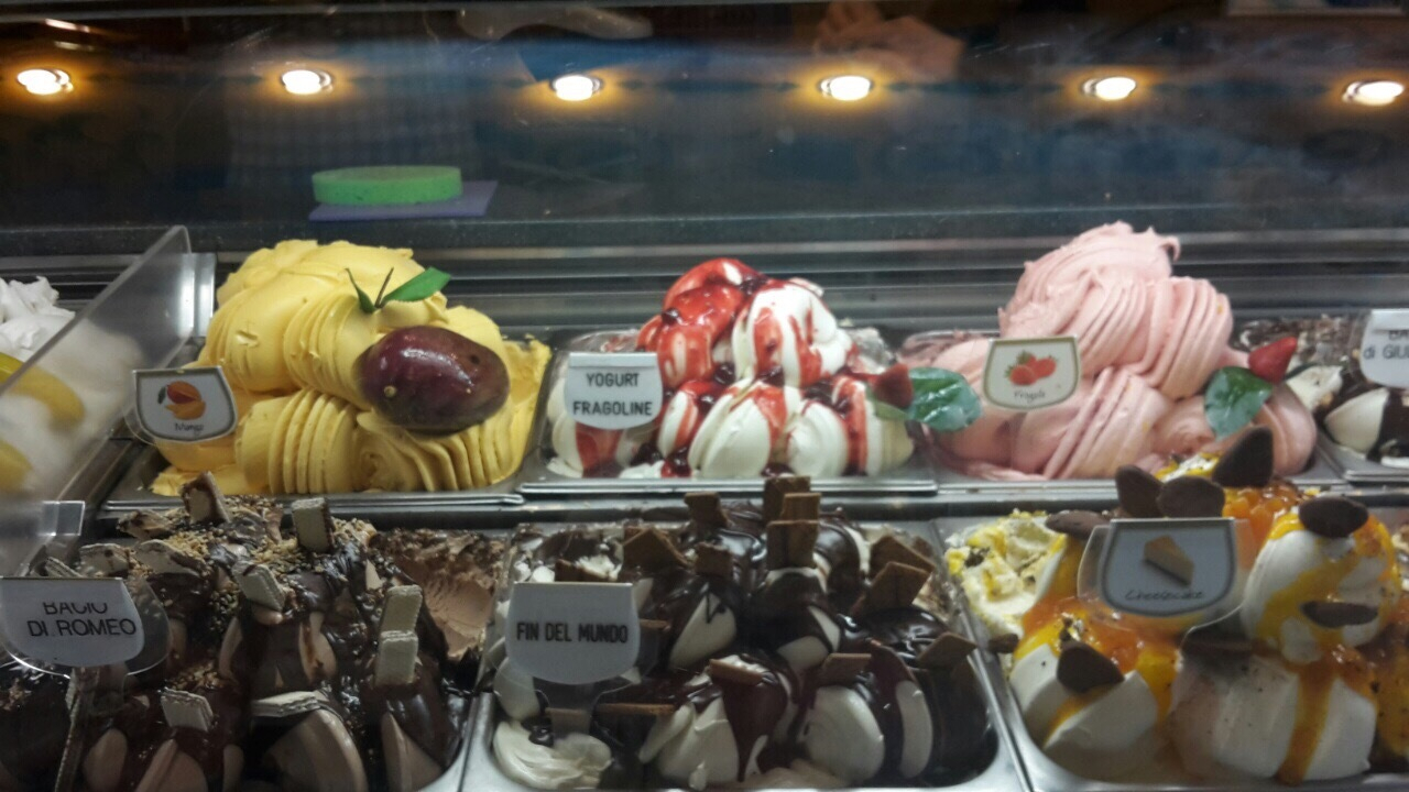 Display of various flavors of gelato in an Italian shop.
