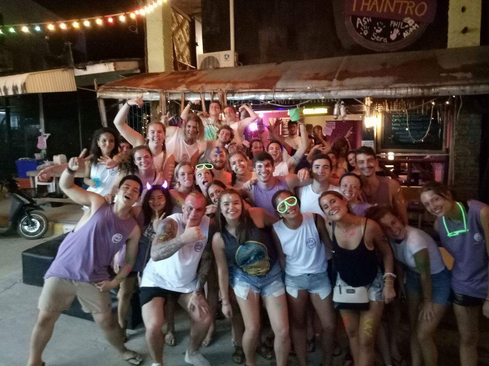 Large group of friends celebrating outside a bar.