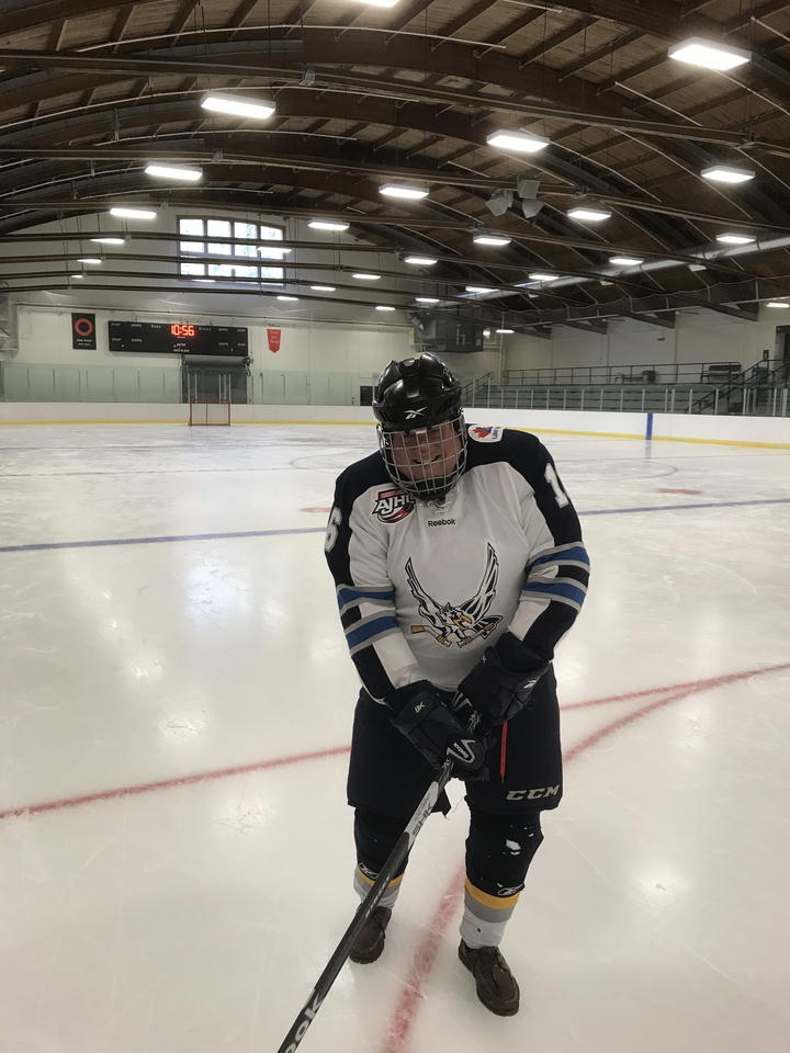 Personne en tenue de hockey sur une patinoire.