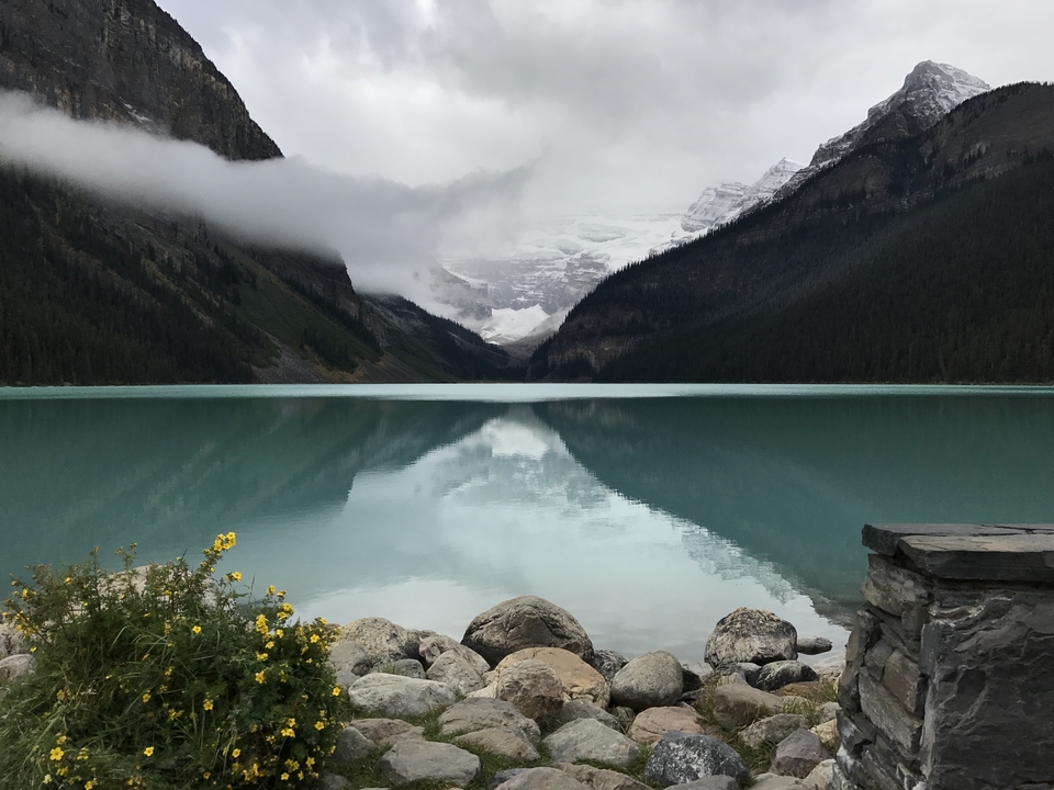 Reflection on a still lake surrounded by majestic mountains.