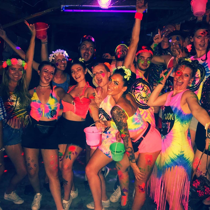Group of people celebrating at a neon-themed party.
