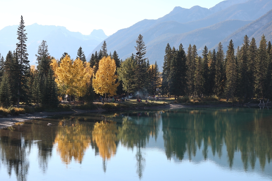 Vue pittoresque d'arbres au feuillage d'automne se reflétant dans un lac calme.
