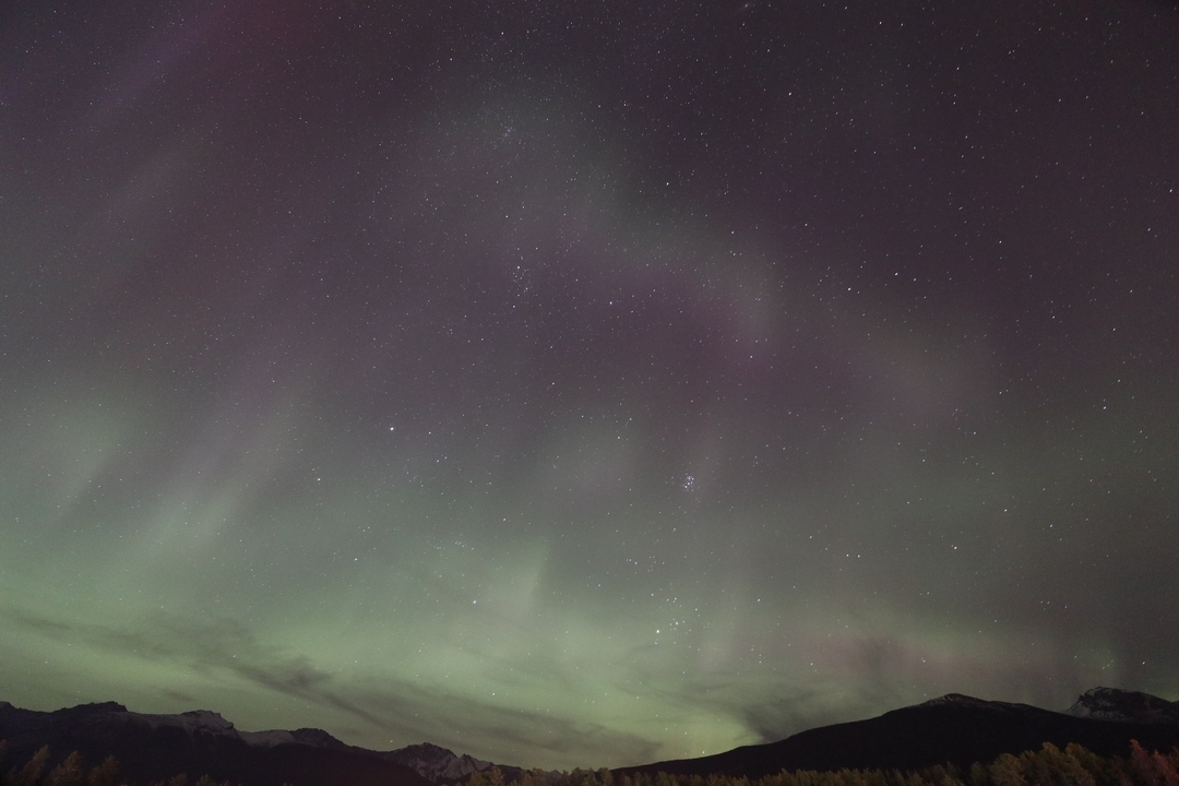 A night sky filled with stars and an appearance of aurora borealis.