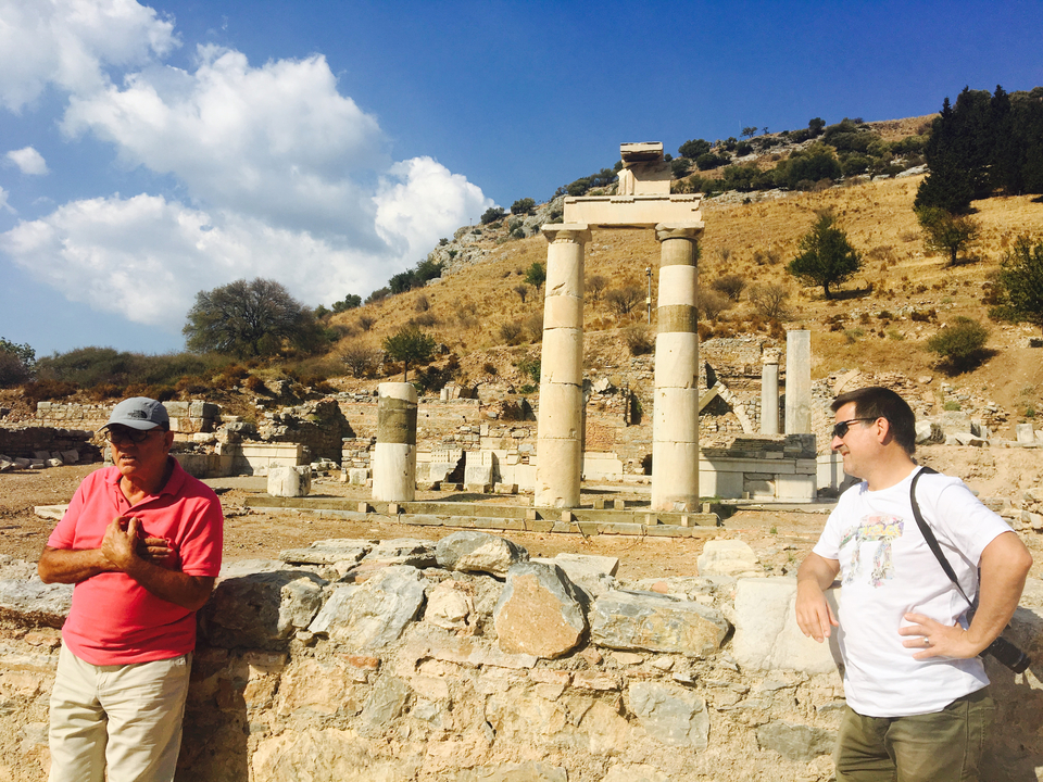 Two men standing in front of ancient ruins.