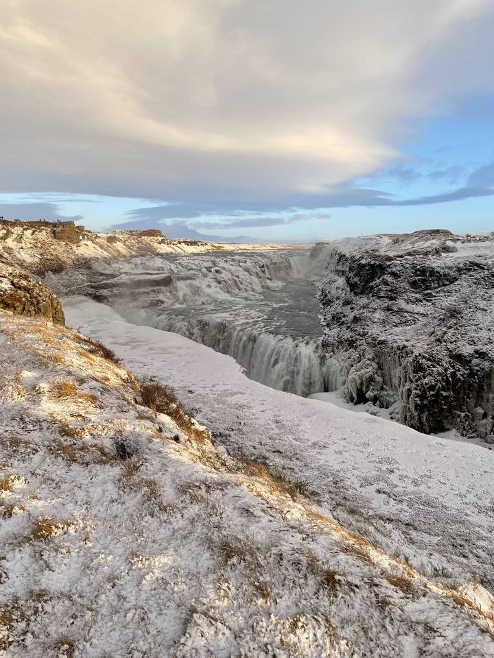 A snow-covered landscape with a waterfall.