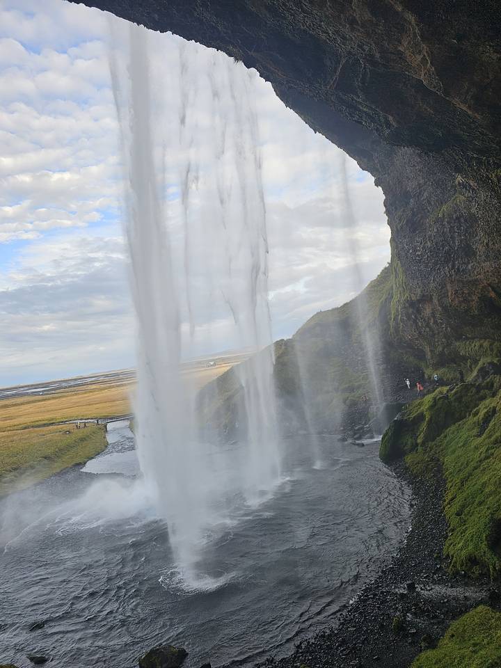 Waterfall viewed from behind with mist rising.