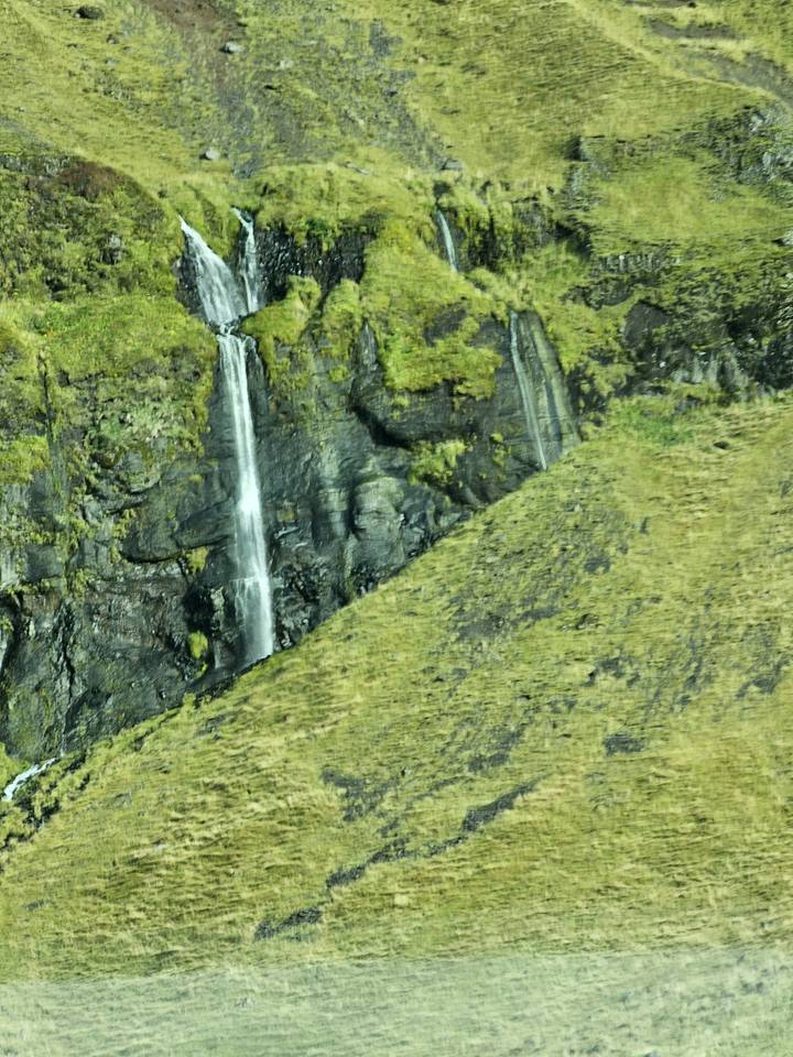 Thin stream of water on a steep cliff.