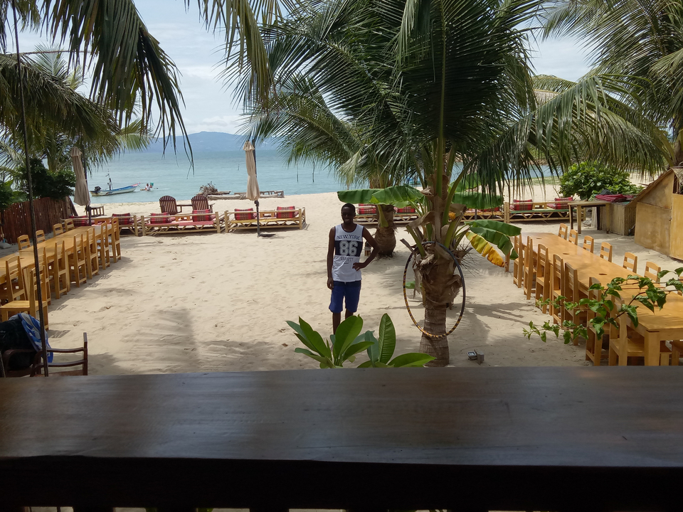Beachfront scene with a single person looking at the ocean.