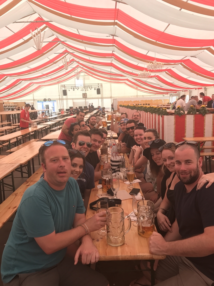 Large group of people sitting at a table in a festival tent.