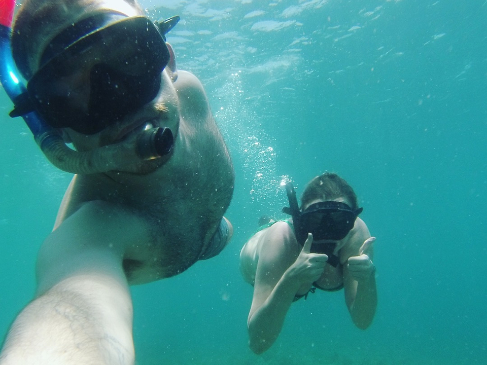 Two people snorkeling underwater.