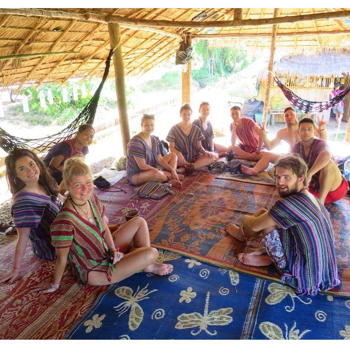 People sitting in a relaxed setting with colorful traditional outfits.