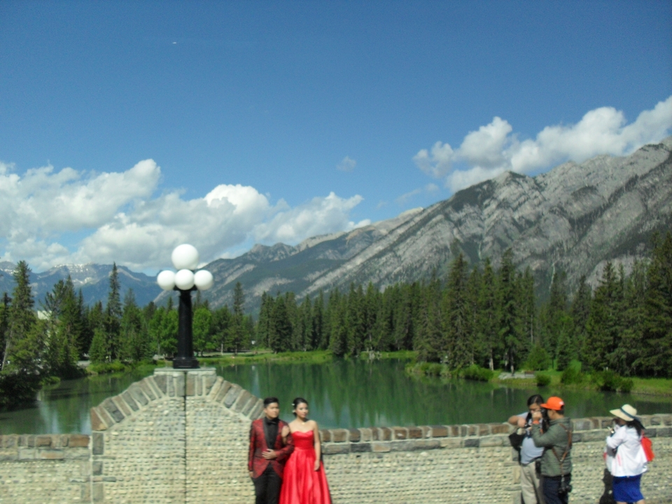 Personnes profitant d'une vue panoramique avec des montagnes et une rivière.