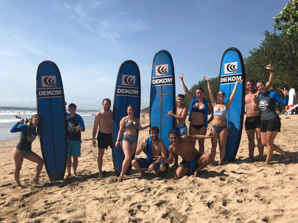 Group of people with surfboards on a beach.