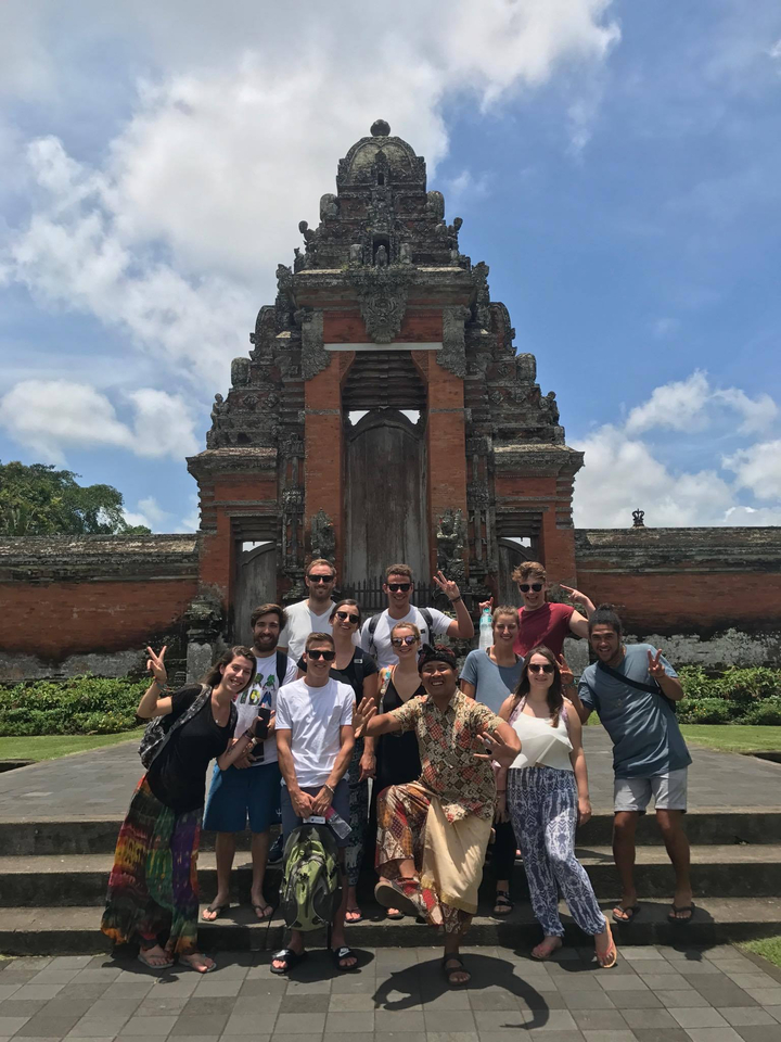 Group of people posing in front of a traditional Balinese gate.